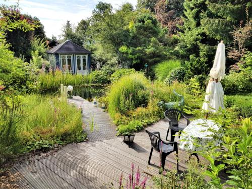 a garden with two chairs and a umbrella at Ferienwohnung im Gartenparadies in Eurasburg