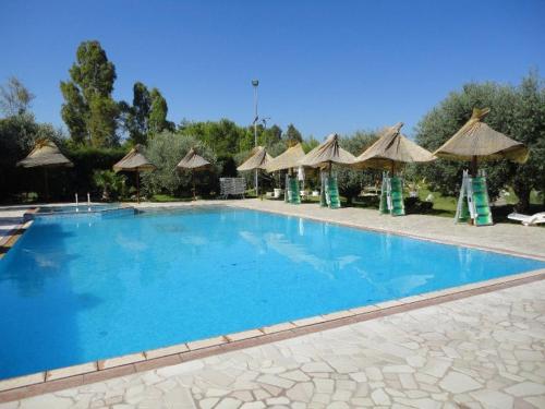 una grande piscina blu con ombrelloni di Le Camporelle In Campagna a Cavallino di Lecce