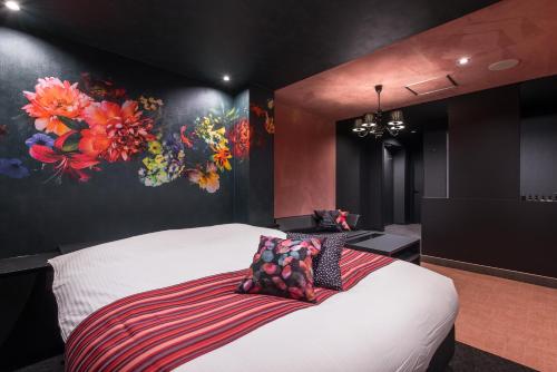 um quarto com uma cama branca e uma pintura na parede em HOTEL FARINA DOLCE (Adult Only) em Kanuma