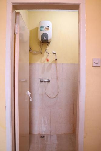 y baño con ducha con cabezal de ducha. en Villa Bukit Indah Brastagi / Berastagi, en Berastagi