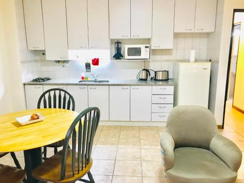 een keuken met een tafel, een tafel en een stoel bij Regency Bombal Apartments in Mendoza