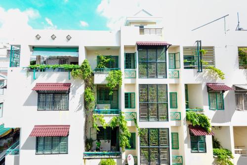 un edificio de apartamentos con ventanas y plantas en Winter Spring Homestay, en Can Tho