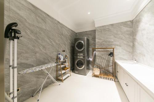 a laundry room with a washer and dryer on the wall at Mercure Ordos Downtown in Ordos