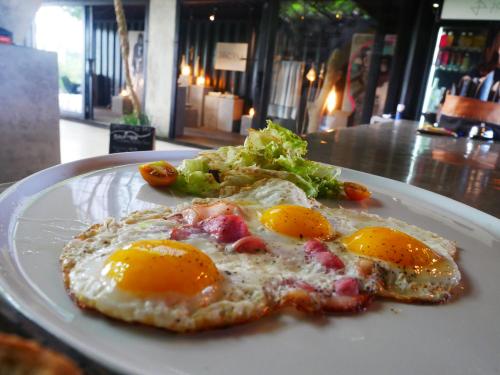 a plate of food with eggs and a salad at Ocean Villa - Joshua District in Tabanan