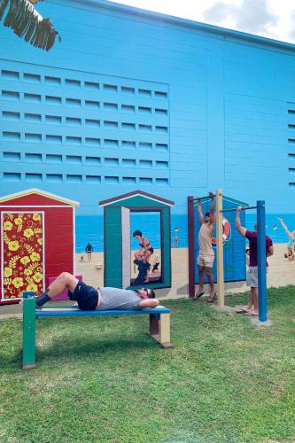 a man laying on a bench in front of a playground at Airlie Beach Magnums - Adults Only in Airlie Beach