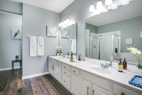 baño con 2 lavabos y espejo grande en Shoreway Loop Unit 206 Condo en Orlando