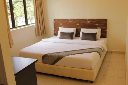 um quarto com uma cama grande e 2 almofadas em Hotel Bandar Baru Menglembu em Ipoh