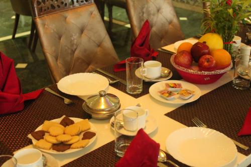 una mesa con platos y tazones de fruta. en Ramada by Wyndham Jaipur Jaisinghpura, en Jaipur