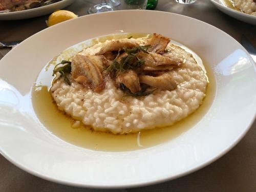 une plaque blanche de nourriture avec du riz et de la viande dans l'établissement Hotel Concordia, à Porlezza