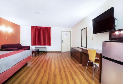 a hotel room with a bed and a flat screen tv at Motel 6-Covington, TN in Covington