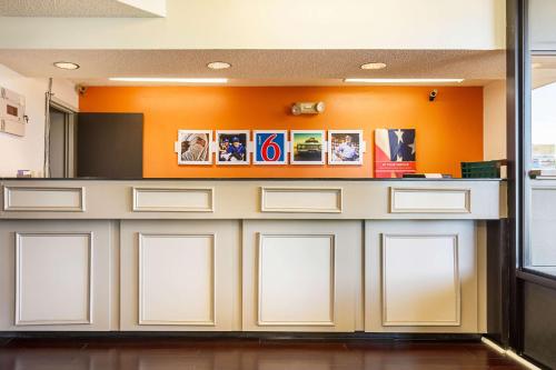 a waiting room with white cabinets and an orange wall at Motel 6-Covington, TN in Covington