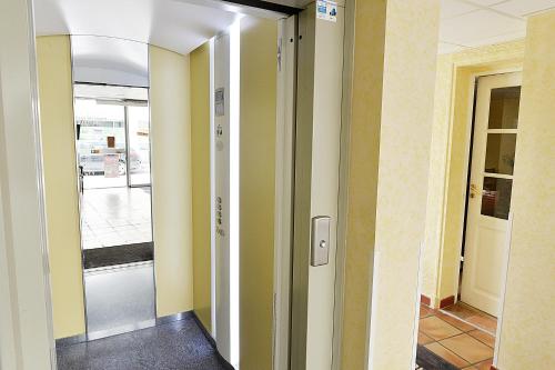 a hallway with yellow walls and a glass door at Hotel De Rosny in Tours