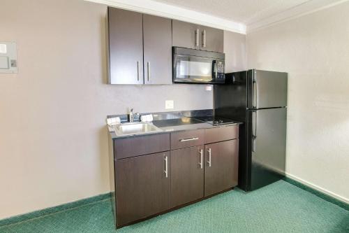 a kitchen with a stainless steel refrigerator and a sink at Studio 6-Fort Worth, TX - West Medical Center in White Settlement