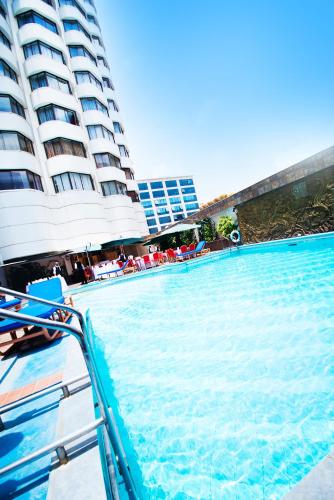 a large swimming pool next to a tall building at Nairobi Safari Club by Swiss-Belhotel in Nairobi