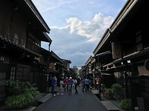 a group of people walking down a street at BEYOND HOTEL Takayama 1st in Takayama