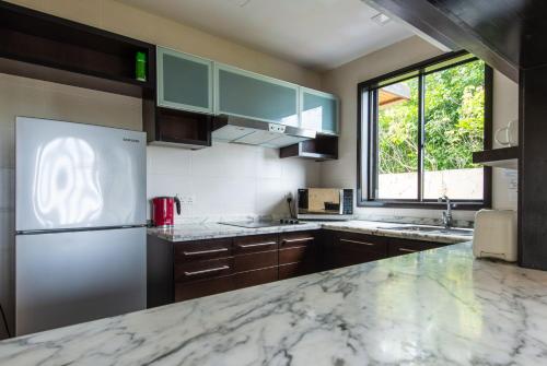 a kitchen with a marble counter top and a refrigerator at Sabah Beach Villas & Suites in Kota Kinabalu