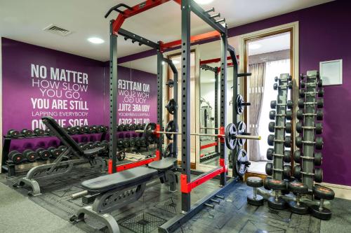 a gym with a purple wall with weights at Holiday Inn Newcastle South by IHG in Boldon