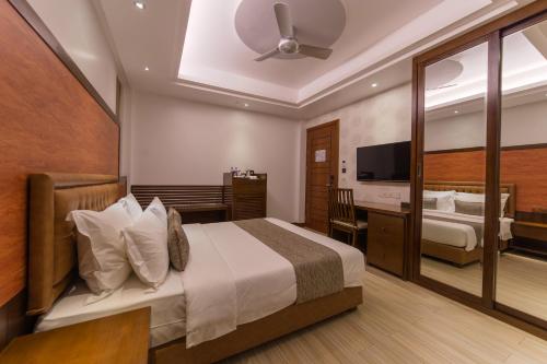 a hotel room with a bed and a television at Samann Host in Hulhumale