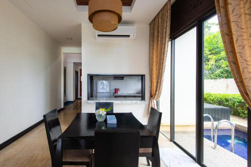 a dining room with a black table and chairs at Sabah Beach Villas & Suites in Kota Kinabalu