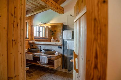 a bathroom with two sinks in a wooden house at Almchalet Linharterhof in Haus im Ennstal