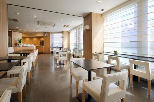 a dining room with tables and white chairs at Keio Presso Inn Nihonbashi Kayabacho in Tokyo
