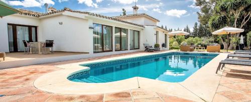 a swimming pool in front of a house at Villa Del Mar in Marbella
