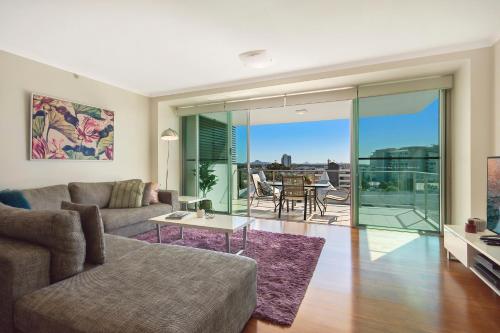 a living room filled with furniture and a large window at m1 Resort in Maroochydore