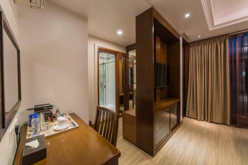 a room with a desk and a television in a room at Samann Host in Hulhumale