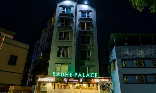 a tall building with a sign on it at night at Treebo Radhe Palace, Lake Town in Kolkata