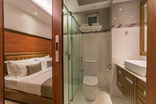 a bathroom with a bed and a shower and a sink at Samann Host in Hulhumale
