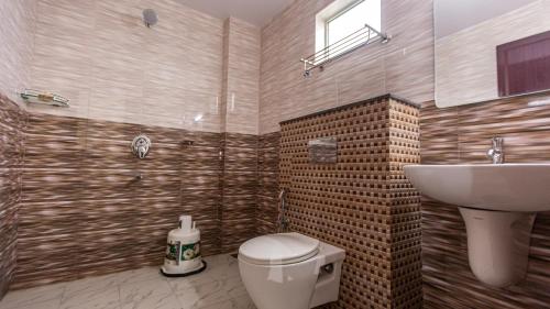 a bathroom with a toilet and a sink at Woodside residency in Thekkady