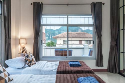 a bedroom with two beds and a large window at Sea Horse Pool villa Ao nang in Ao Nang Beach