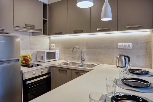 a kitchen with a sink and a microwave at Keramikos Comfortable apartment #1 in Athens