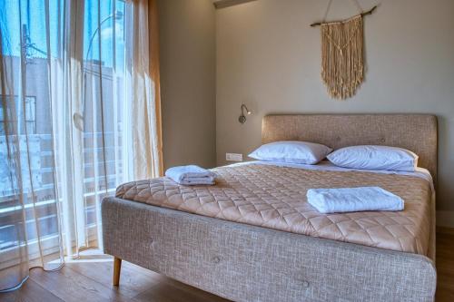 1 dormitorio con 1 cama con 2 toallas en Keramikos Comfortable apartment #1 en Athens