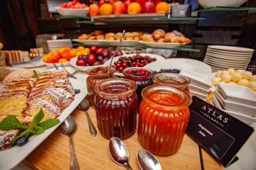 a table topped with food and jars of jam at Hotel Atlas Deluxe in Lviv