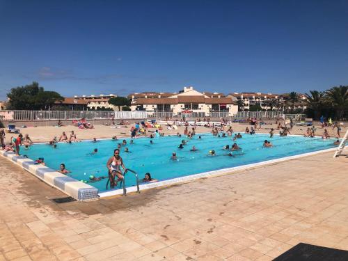 un groupe de personnes dans une piscine dans l'établissement Residence Caraibes -Cap Coudalere,, au Barcarès