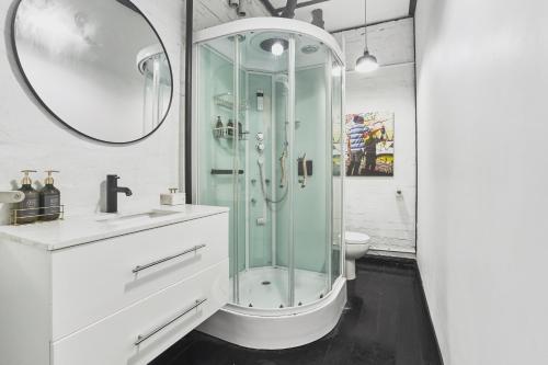 uma casa de banho com uma cabina de duche em vidro e um WC. em The Blender Loft em Melbourne