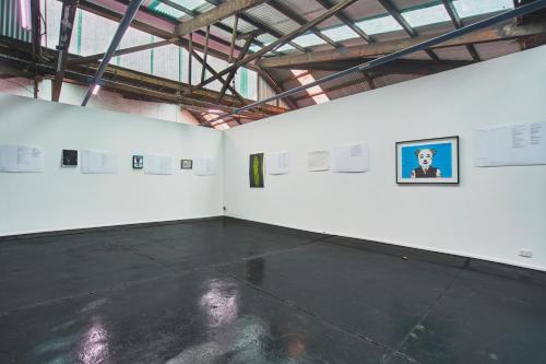 um quarto branco com uma foto de um homem na parede em The Blender Loft em Melbourne