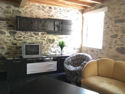 a living room with a television and a chair at Casa Rural Ortigueira in A Coruña