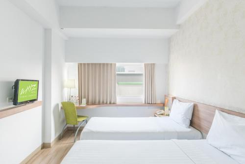 Ένα ή περισσότερα κρεβάτια σε δωμάτιο στο Whiz Hotel Cikini Jakarta