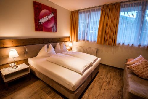 a hotel room with a bed and a couch at Hotel-Appartement Ferienhof in Gerlos