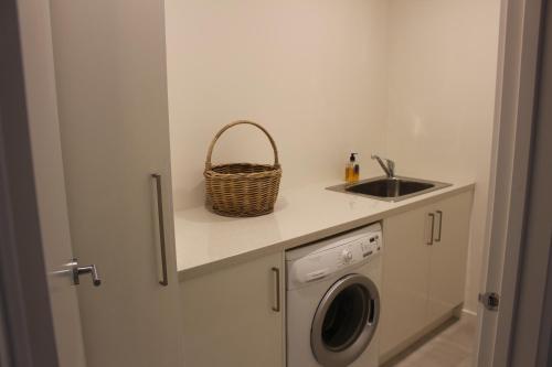 a laundry room with a sink and a washing machine at kanburra house in Rye
