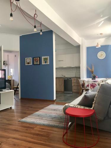 ein Wohnzimmer mit einer blauen Wand und einem roten Stuhl in der Unterkunft Klimatyczne mieszkanie na Starym Mieście in Płock