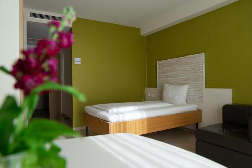 a small bedroom with a bed and green walls at first Apart in Erlangen