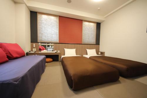 una camera d'albergo con 2 letti e una scrivania di Urbain Kyoto Kiyomizugojo a Kyoto