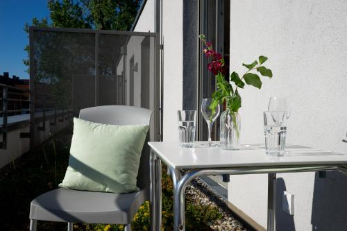 a white table and chair with a pillow on a balcony at first Apart in Erlangen