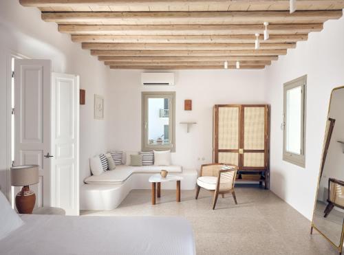 a living room with white walls and a wooden ceiling at Belvedere Mykonos - Hilltop Rooms & Suites - The Leading Hotels of the World in Mýkonos City