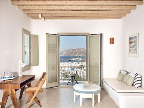a living room with a white couch and a table at Belvedere Mykonos - Hilltop Rooms & Suites - The Leading Hotels of the World in Mýkonos City