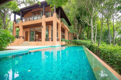 a house with a swimming pool in front of a house at Sri Panwa Phuket Luxury Pool Villa Hotel - SHA Plus in Panwa Beach