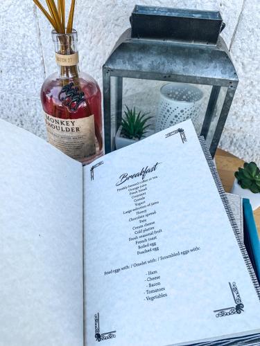 una bottiglia di whisky appoggiata sopra un menu di Limestone Heritage House a Trogir